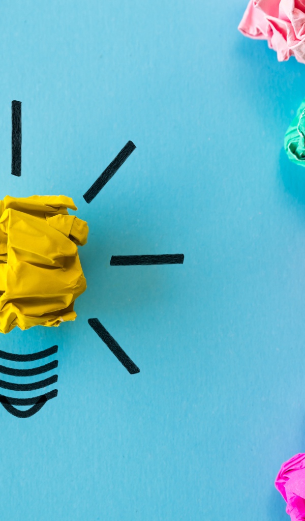 Комки разноцветной бумаги на голубом фоне 