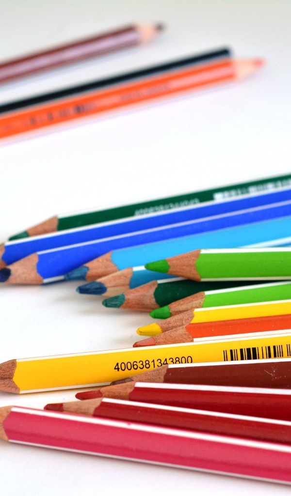 Разноцветные карандаши на белом столе 