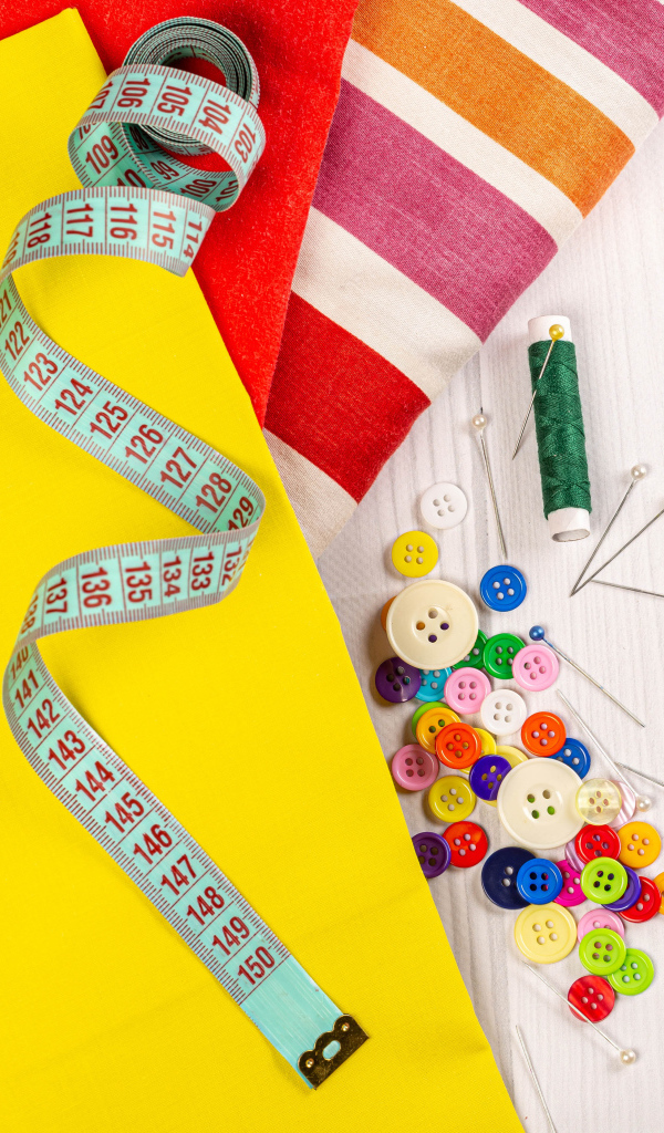 Разноцветная бумага и набор для шитья на столе 