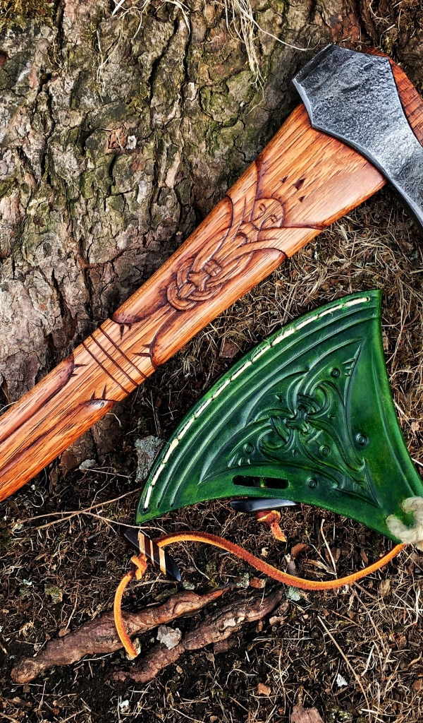 Старый топор с рисунком у дерева 