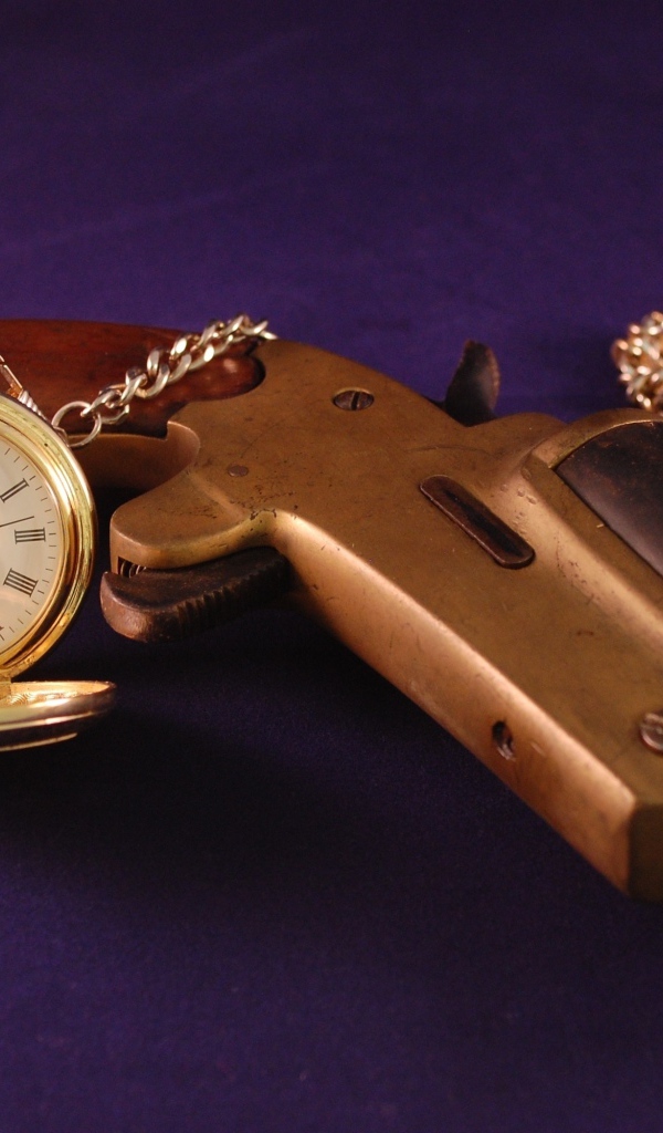 Старый пистолет с песочными часами на фиолетовом фоне