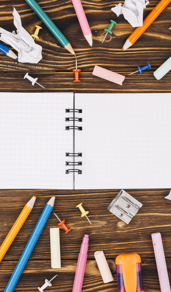 Открытый блокнот с ручками  на столе 