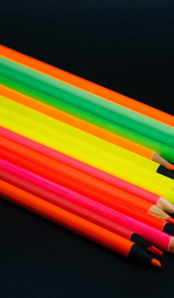 Палитра разноцветных карандашей на черном фоне