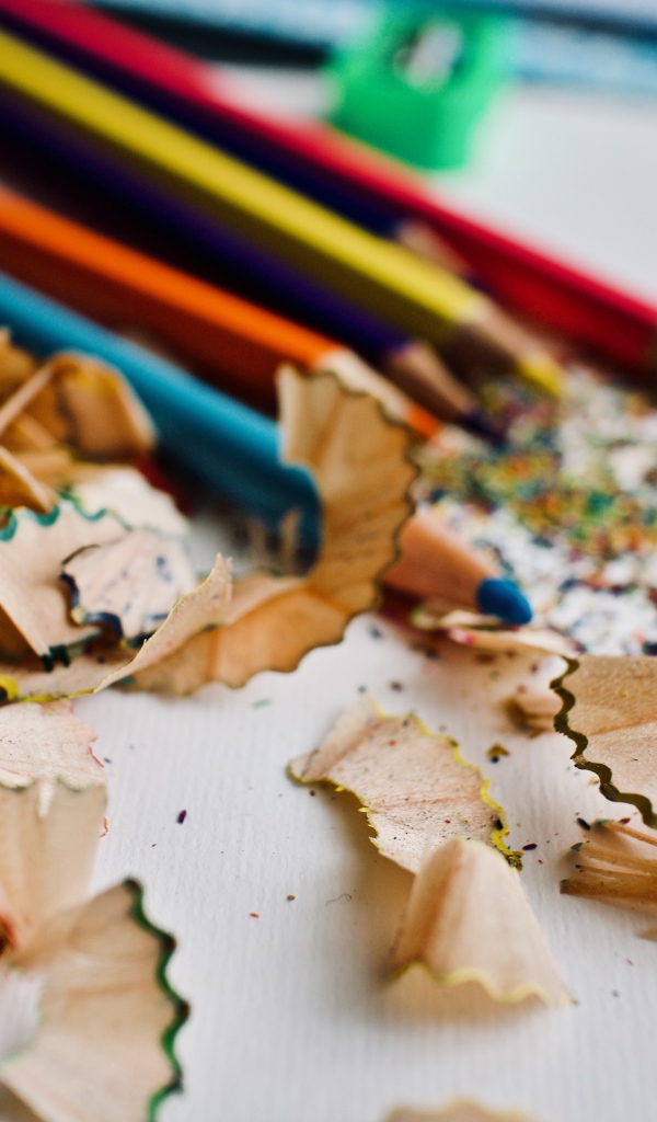 Карандаши со стружкой на сером столе 