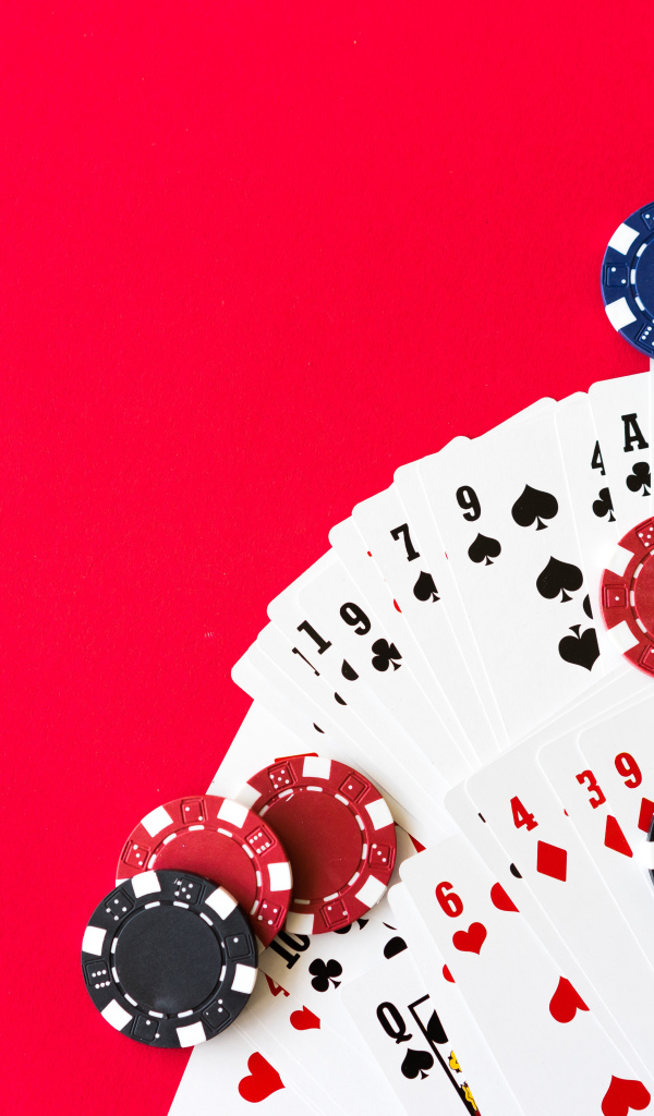 Карты для покера и фишки на красном фоне 