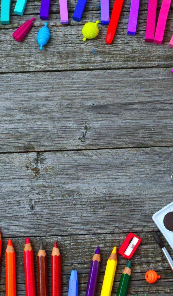 Радуга ярких канцелярских предметов для школы  на деревянном столе