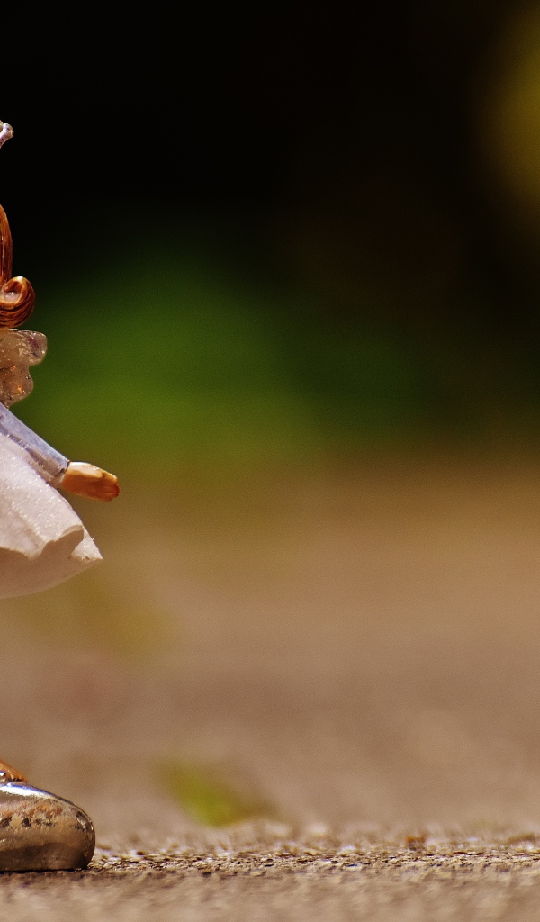 Статуэтка принцесса стоит на асфальте 