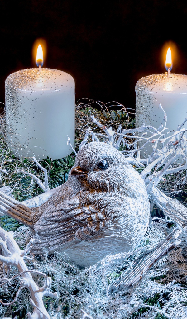 Три зажженные свечи со статуэтками птицами 