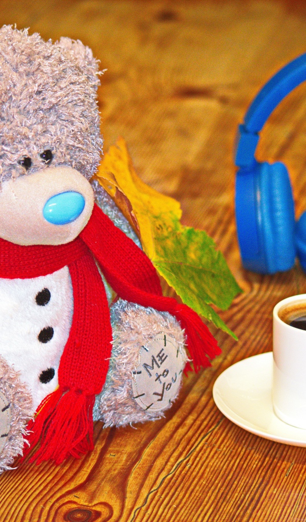 Игрушечный медведь с наушниками и чашкой кофе