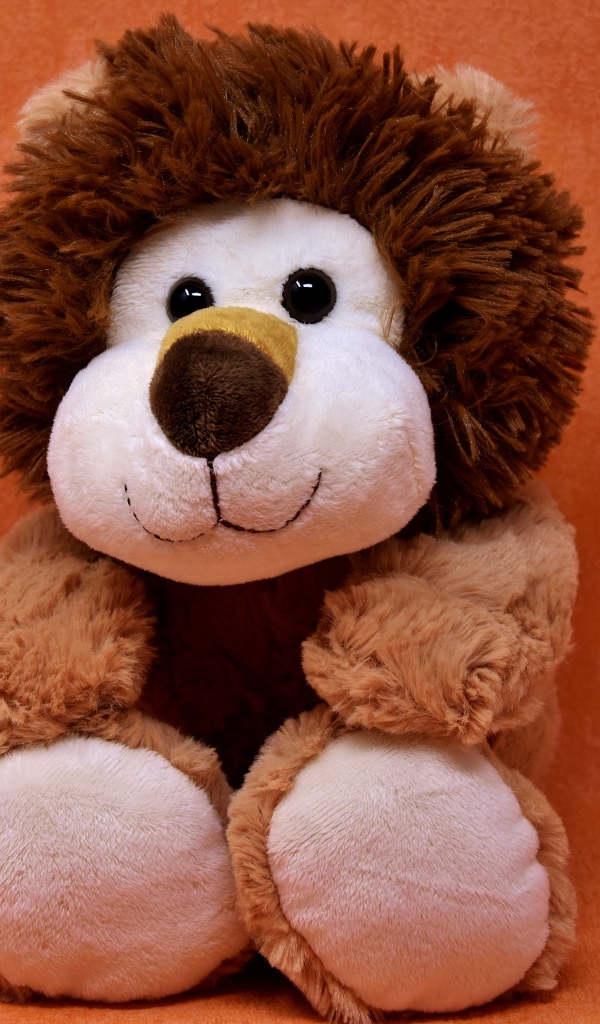 Игрушечный лев на фоне стены