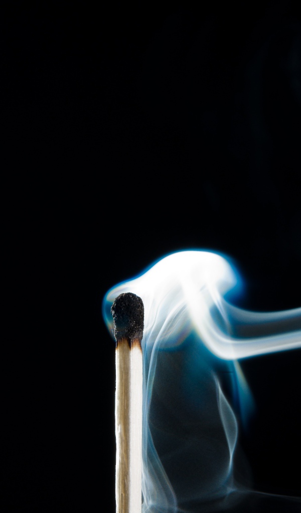 Белый дым от сожженной спички на черном фоне