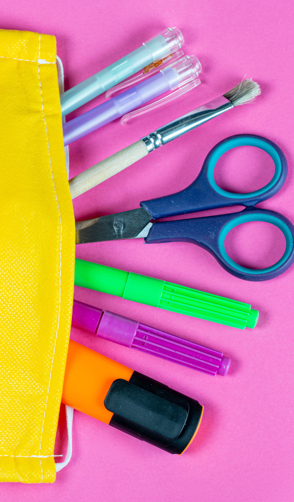 Желтая медицинская маска с ручками и ножницами на  розовом фоне