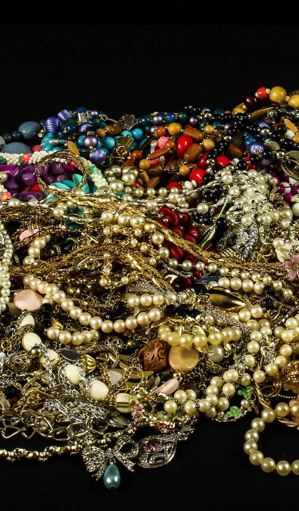 Много драгоценных ювелирных украшений на черном фоне