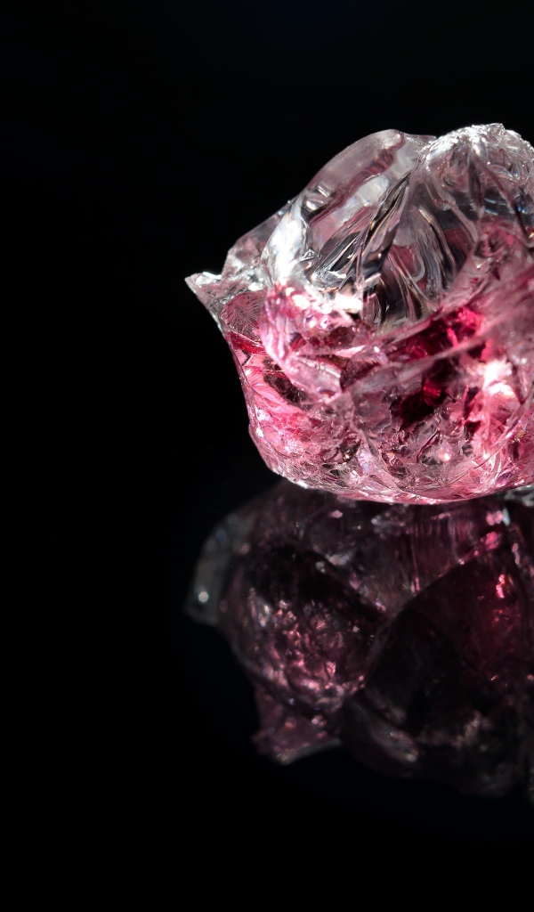 Розовый драгоценный камень на черном фоне 