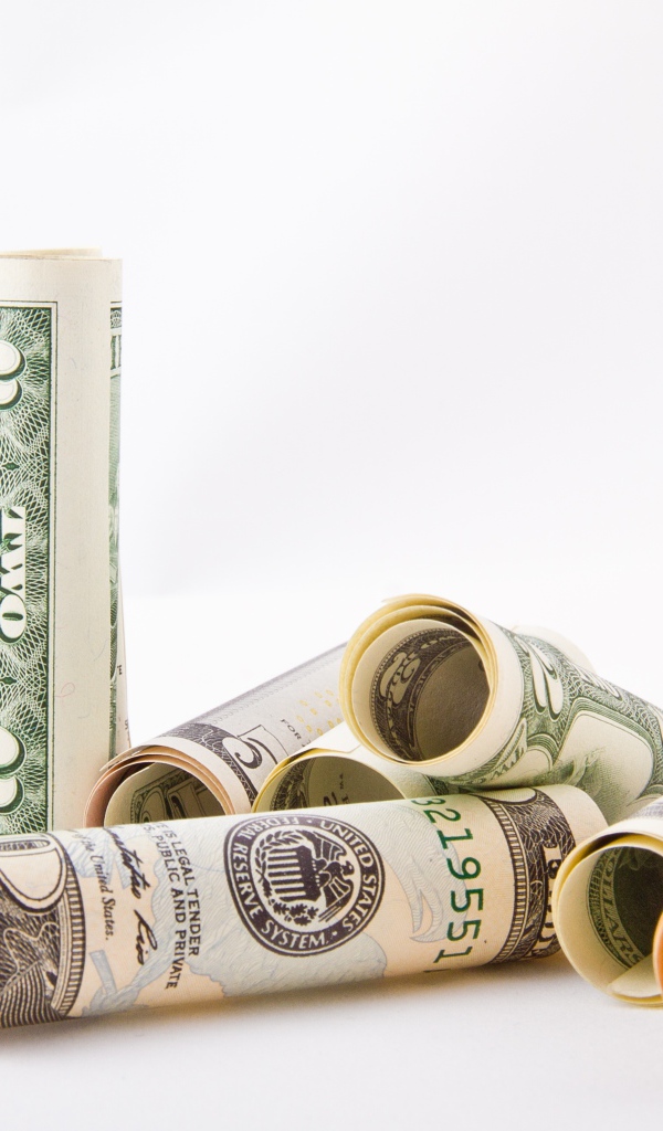 Скрученные в трубочки доллары на белом фоне 