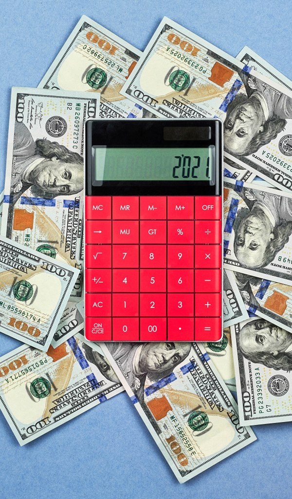 Много долларов с калькулятором на синем фоне