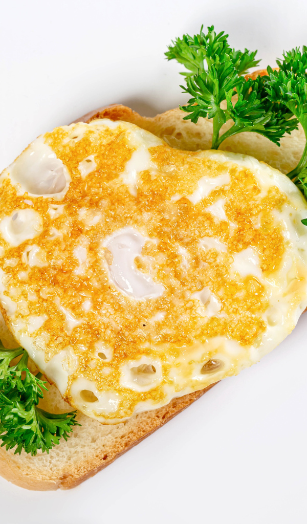 Кусок хлеба с яичницей и петрушкой