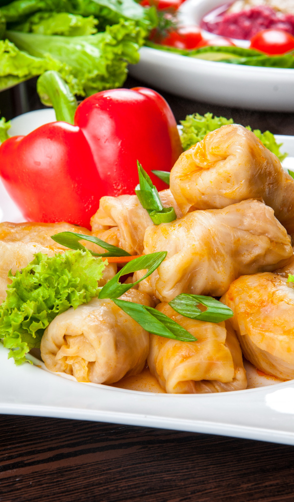 Аппетитные голубцы на тарелке с перцем 