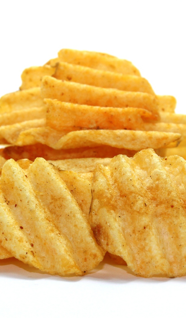 Аппетитные картофельные чипсы на сером фоне