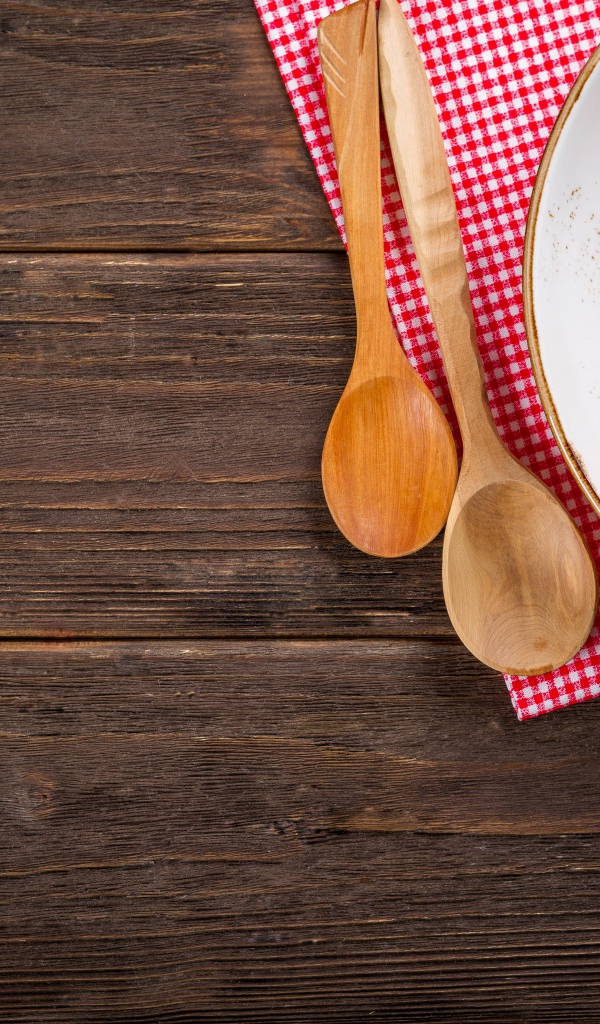 Руккола с помидорами на тарелке с ложками 