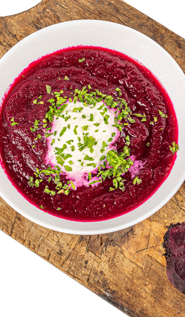 Свекольный суп в тарелке на белом фоне