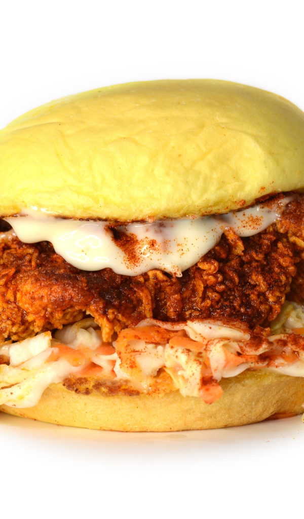 Большой куриный бургер с соусом на белом фоне