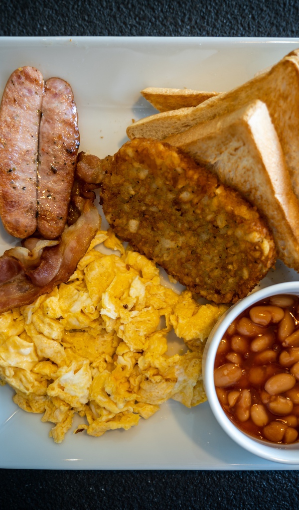 Завтрак на белой тарелке на черном столе 