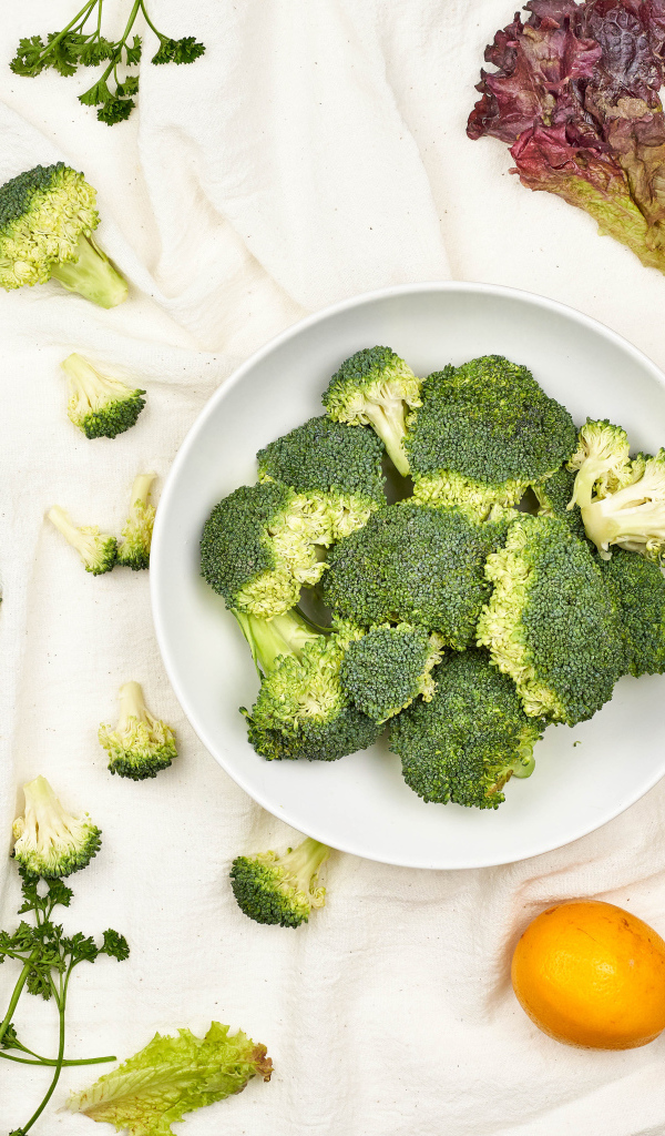 Брокколи на столе с помидорами и зеленью