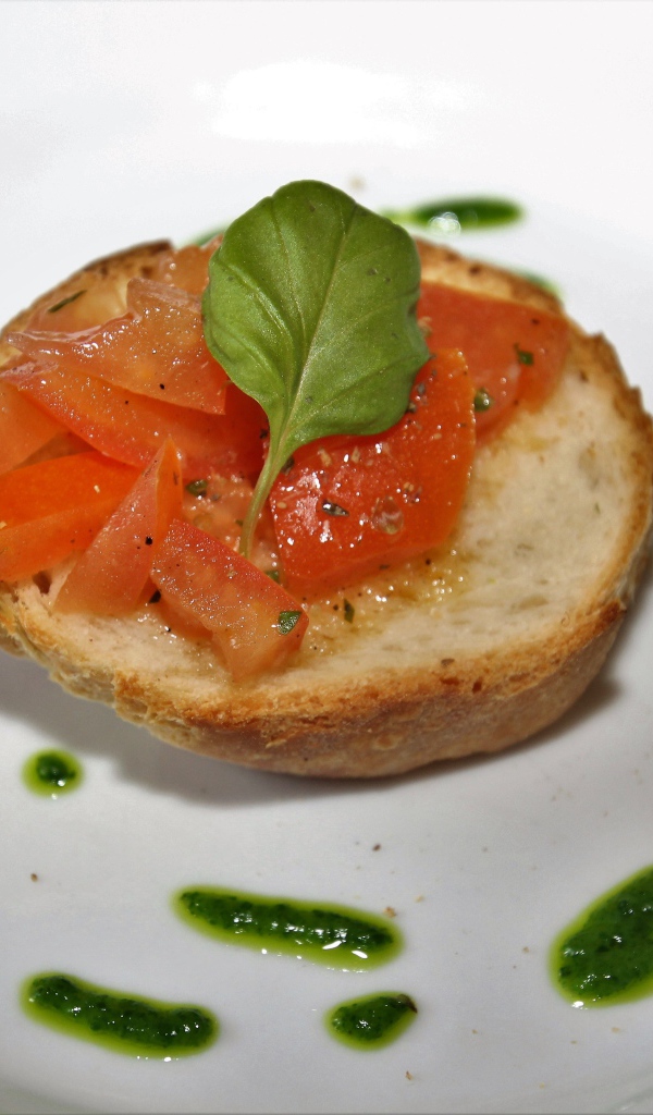 Брускетта на тарелке с помидорами и соусом