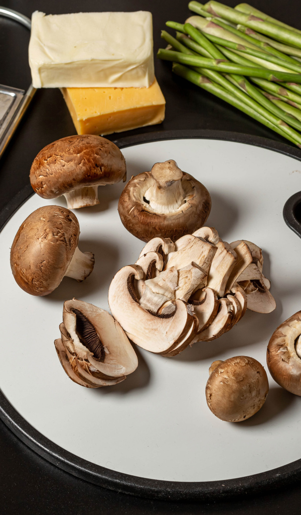 Шампиньоны на столе со спаржей и помидорами 