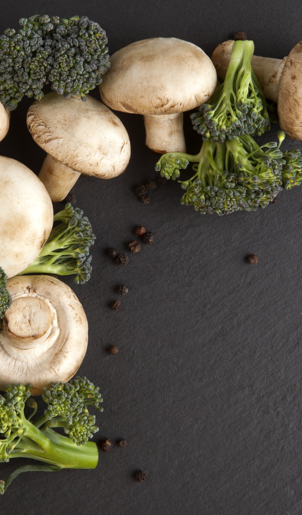 Шампиньоны с брокколи на сером столе 
