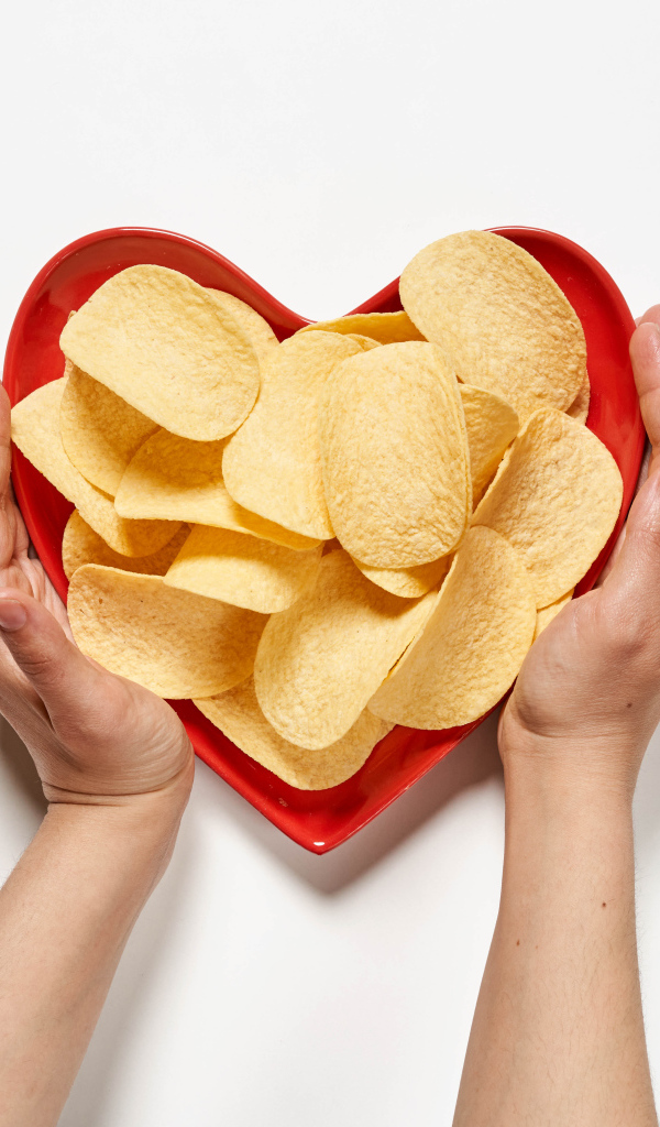 Чипсы в красной тарелке на белом фоне