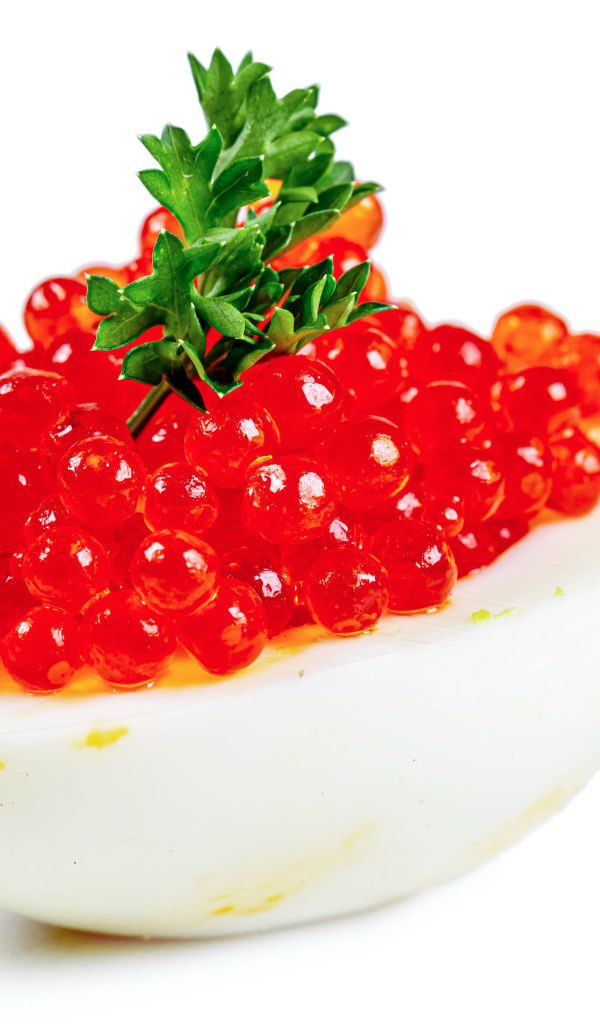 Яйцо фаршированное красной икрой на белом фоне