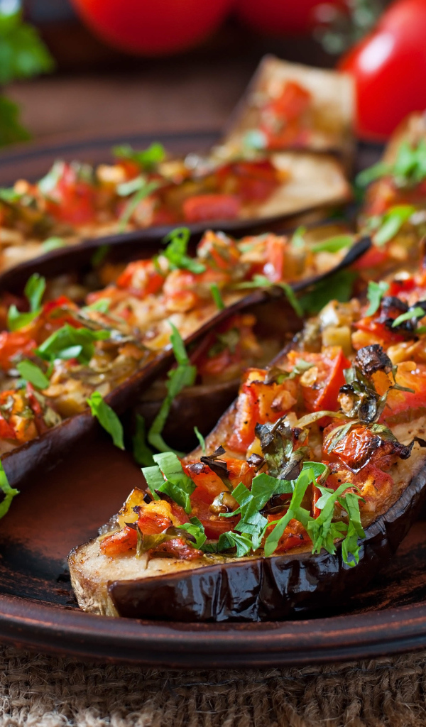 Баклажаны начиненные овощами на тарелке 