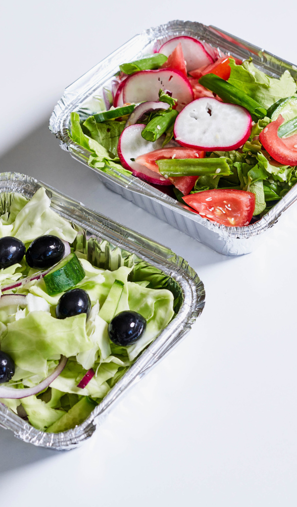 Салат из свежих овощей в тарелках на сером фоне 