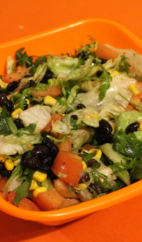 Салат из свежих овощей на оранжевом фоне