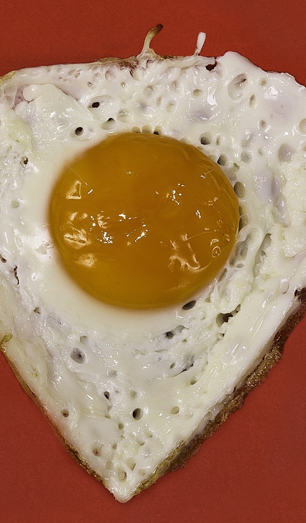 Яичница глазунья на красном фоне