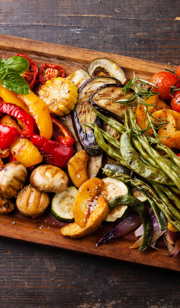 Запеченные на гриле овощи на разделочной доске 