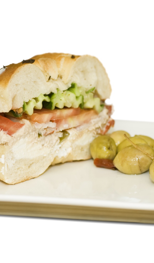 Половина гамбургера на тарелке с оливками