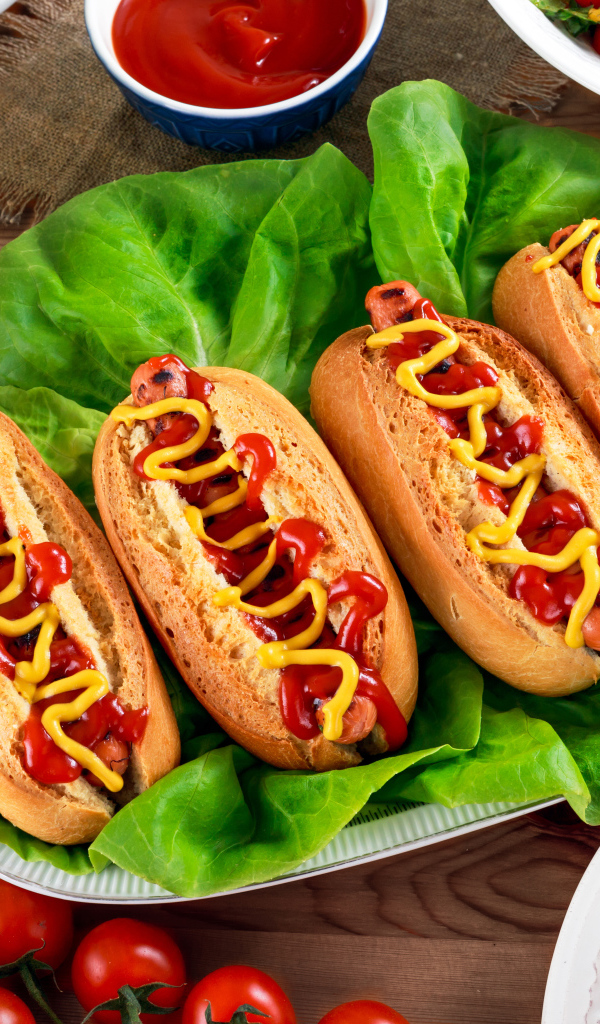 Хотдоги, пицца, лимонад и салат на столе