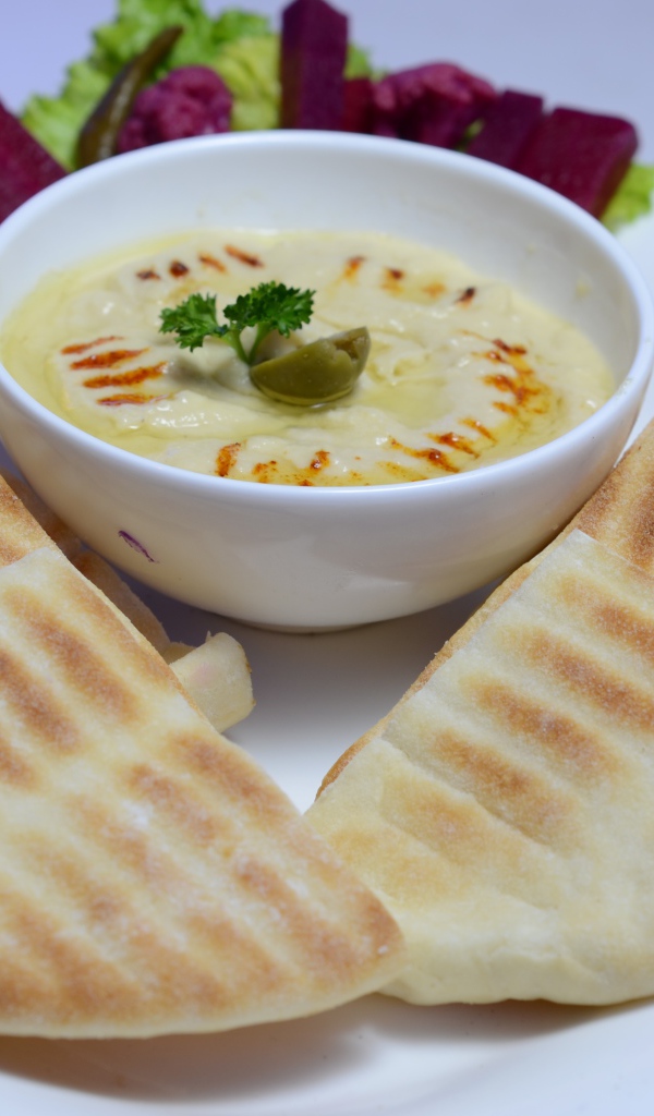 Хумус в белой тарелке с лавашом