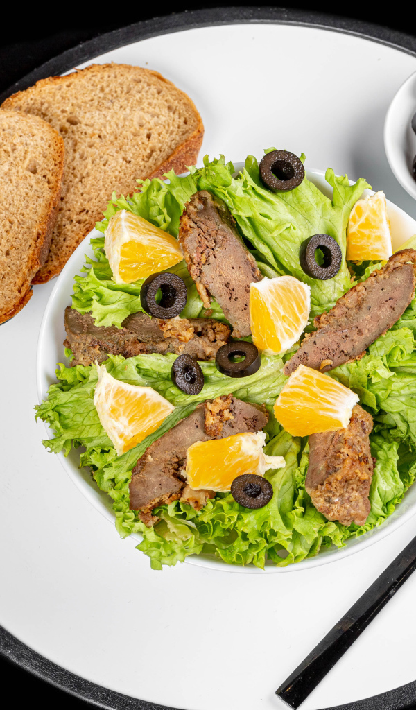 Листья салата с мясом на столе с хлебом