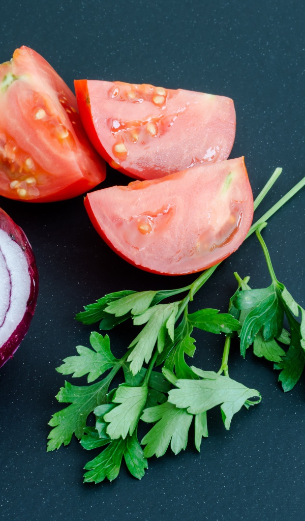 Лук, помидоры и петрушка на сером столе