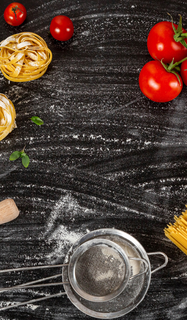 Паста с помидорами и яйцами на черном столе 