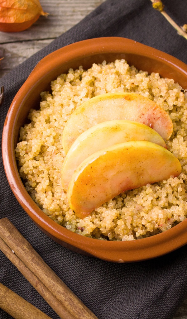 Каша в миске с кусочками яблока