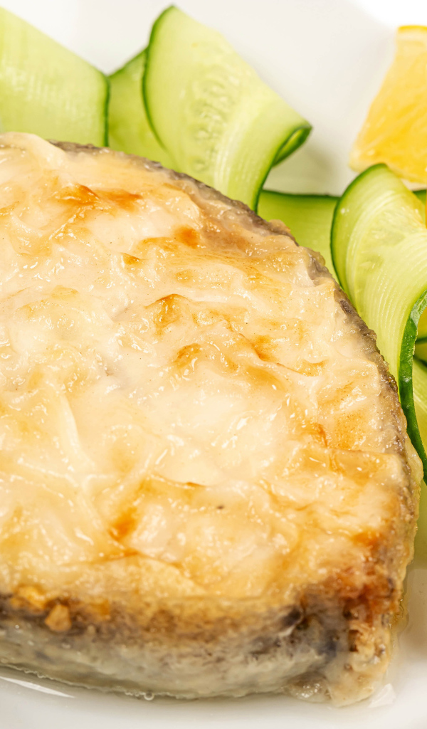 Картофель с сыром на тарелке с огурцами и лимоном 