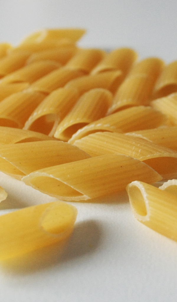 Сырые желтые макароны на сером фоне