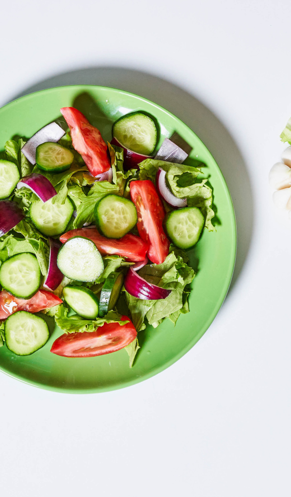 Салат с огурцами, луком, помидорами и листьями салата