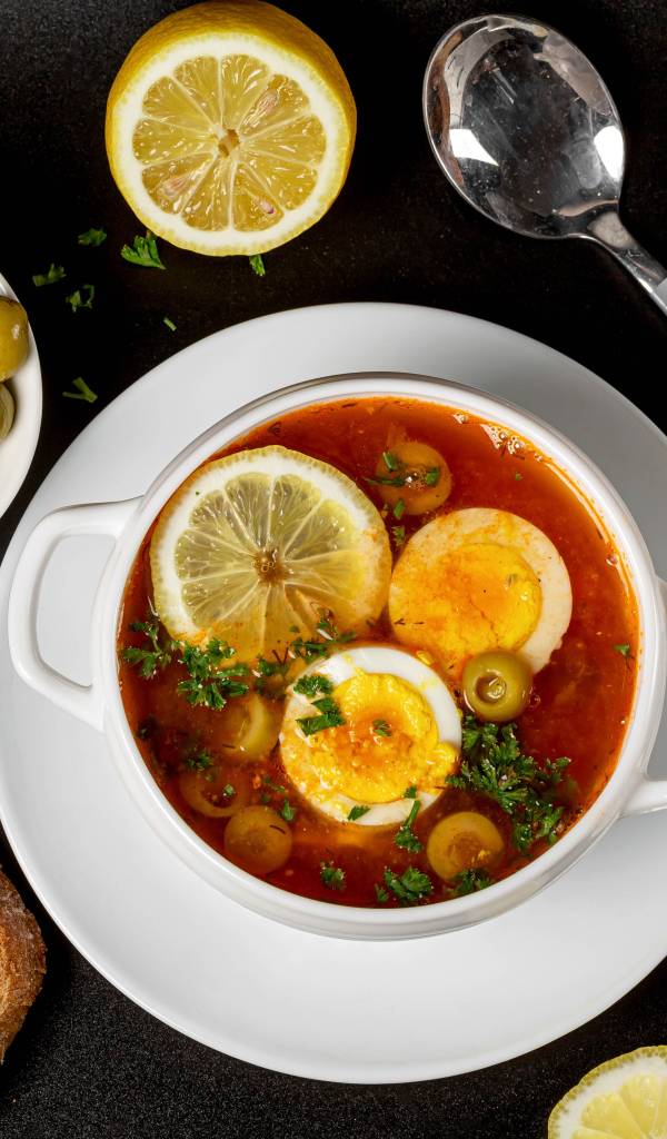 Солянка на столе  с хлебом и оливками 