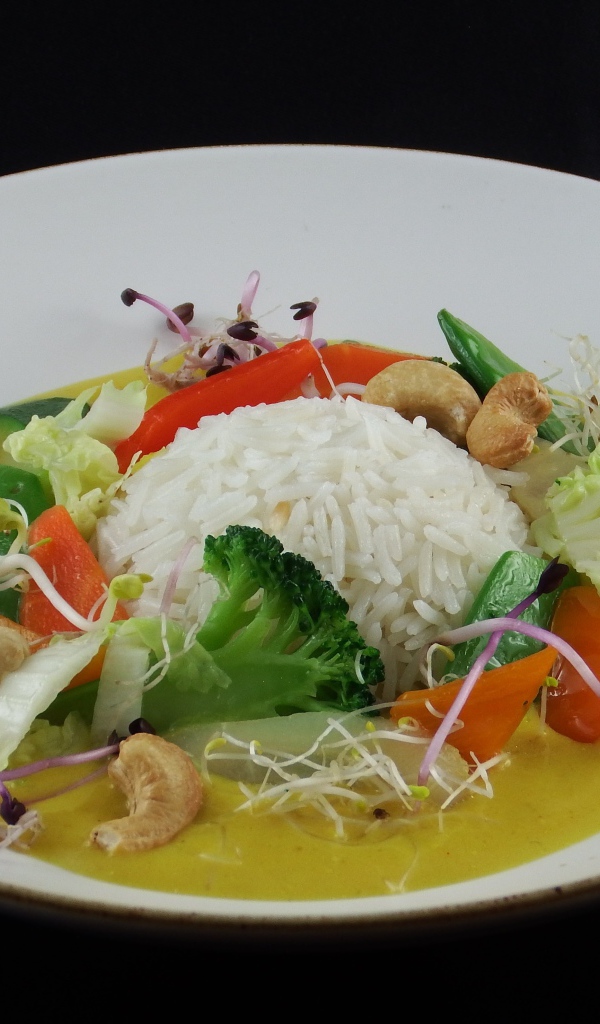 Вареный рис с овощами в большой белой тарелке